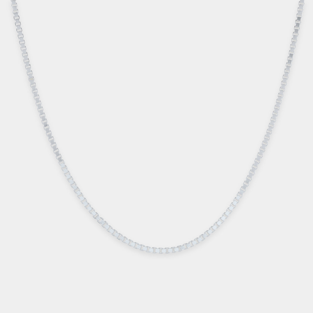 Silver chain necklace on a light gray background