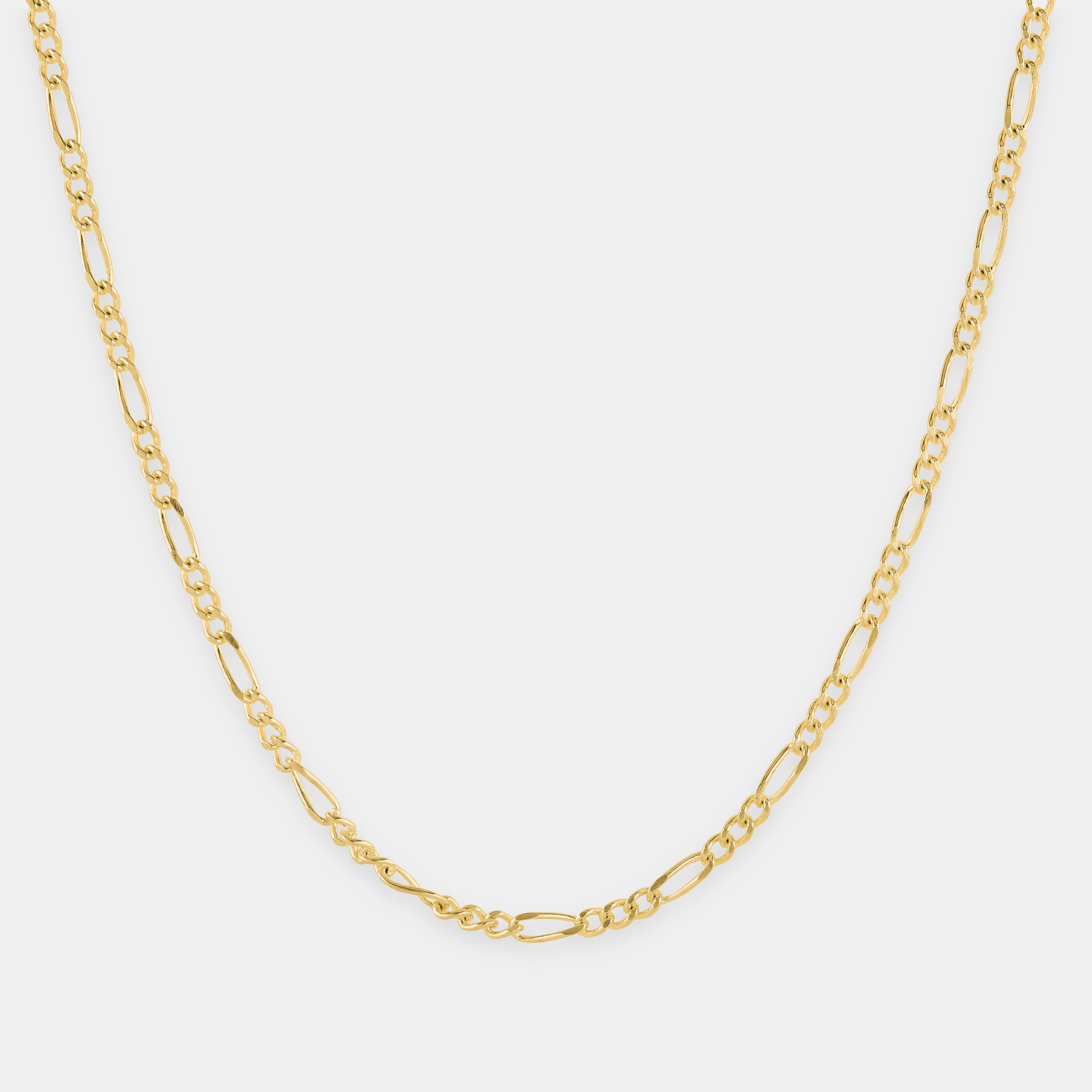 Gold chain necklace on a light gray background